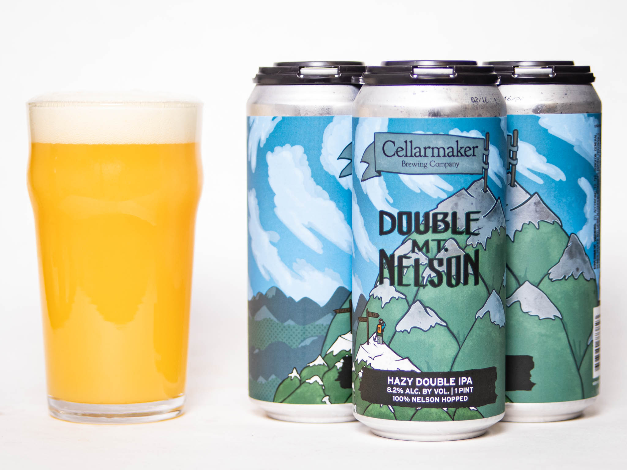 A Glass Of Hazy Yellow Beer Sits Beside Four Cans Of Cellarmaker Brewing Company’s Double Mt. Nelson Ipa, Featuring Illustrated Mountain Scenery On The Can Labels.