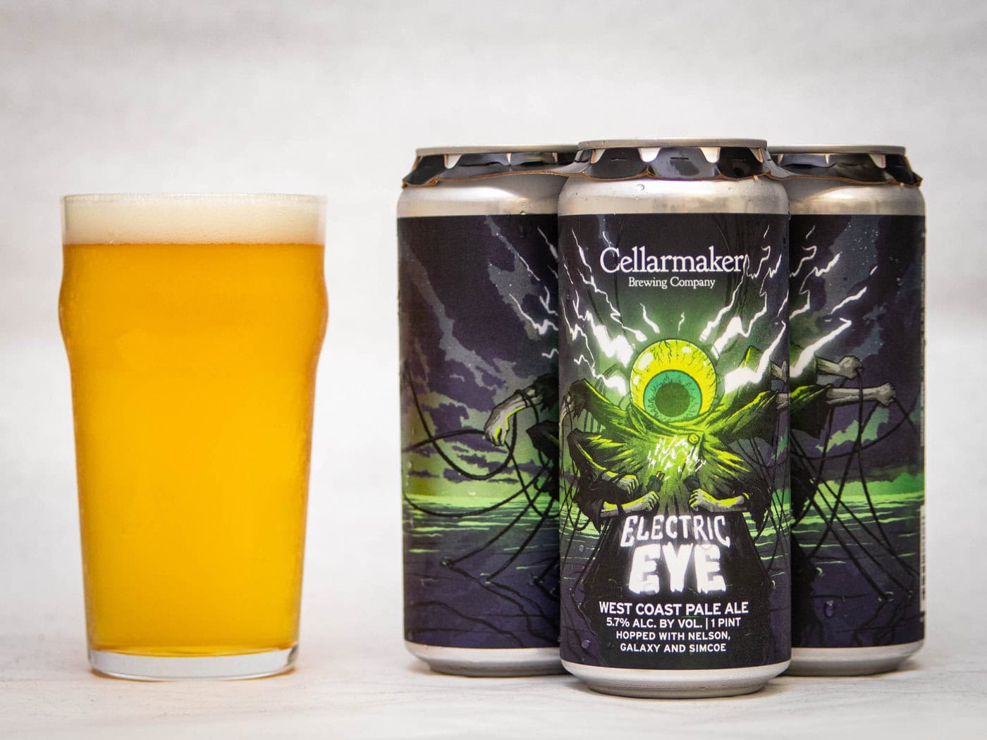 A Glass Of Hazy Golden Beer Sits Next To Three Cans Of Wild Gooseberry Chase - Hazy Ipa, Each Can Featuring A Vibrant Label Design.