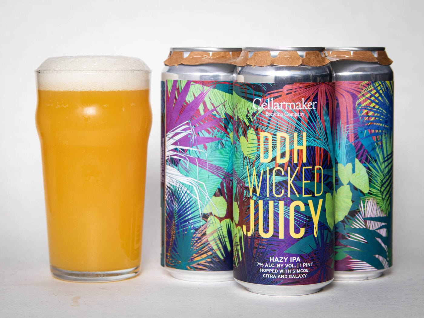 A Pint Glass Of Hazy, Golden Beer Sits Next To A Four-Pack Of Colorful Cans Labeled &Amp;Quot;Foreign Object - Wc Ipa - Tdne Collab,&Amp;Quot; Each Featuring Vibrant, Tropical-Inspired Artwork.