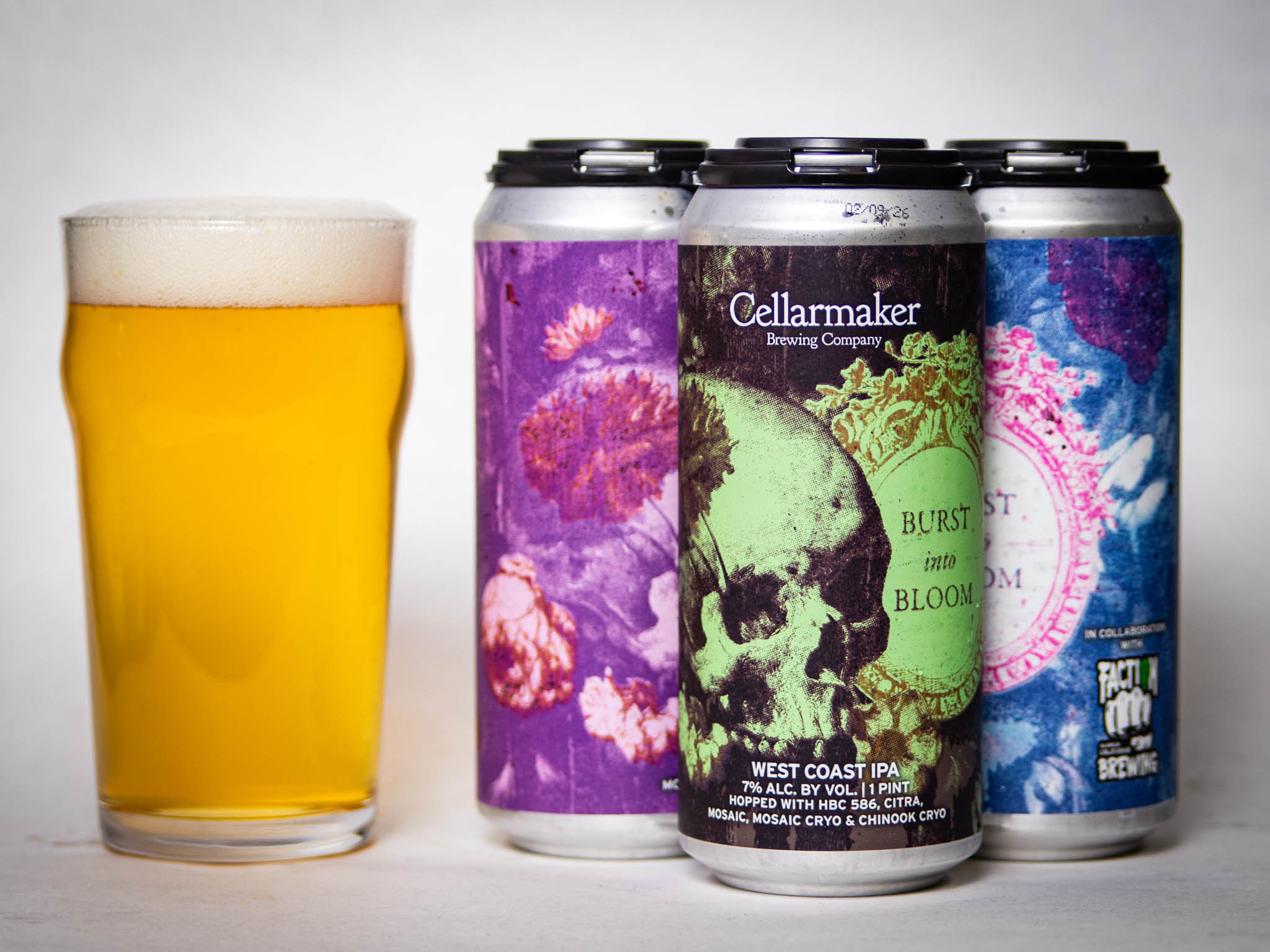 A Pint Glass Of Hazy Golden Beer Sits Beside Three Colorful Cans Labeled &Amp;Quot;Cellarmaker Brewing Company Burst Into Bloom West Coast Ipa,&Amp;Quot; Featuring Vibrant Floral And Skull Artwork.